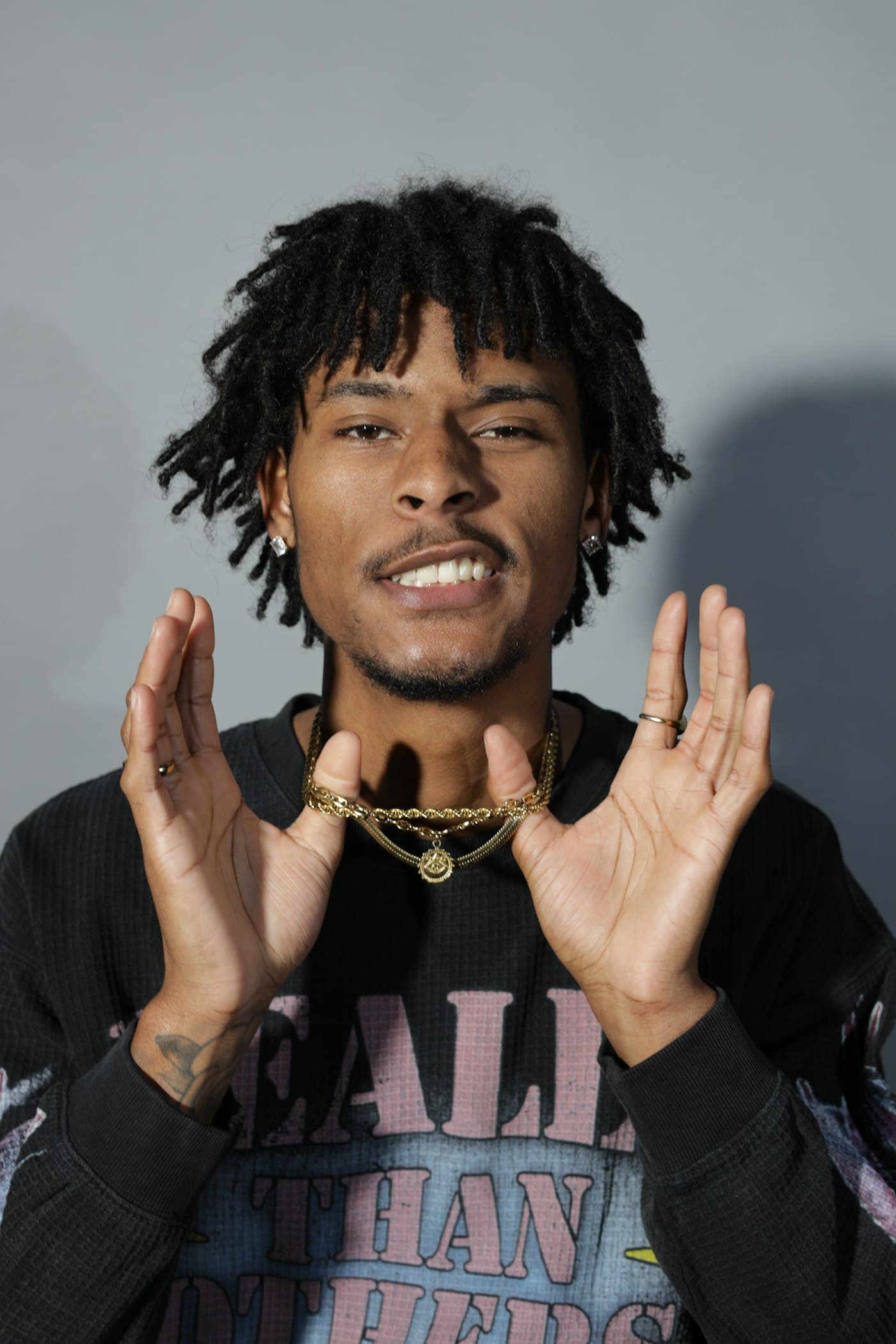 A man wearing gold chains and a custom pendant