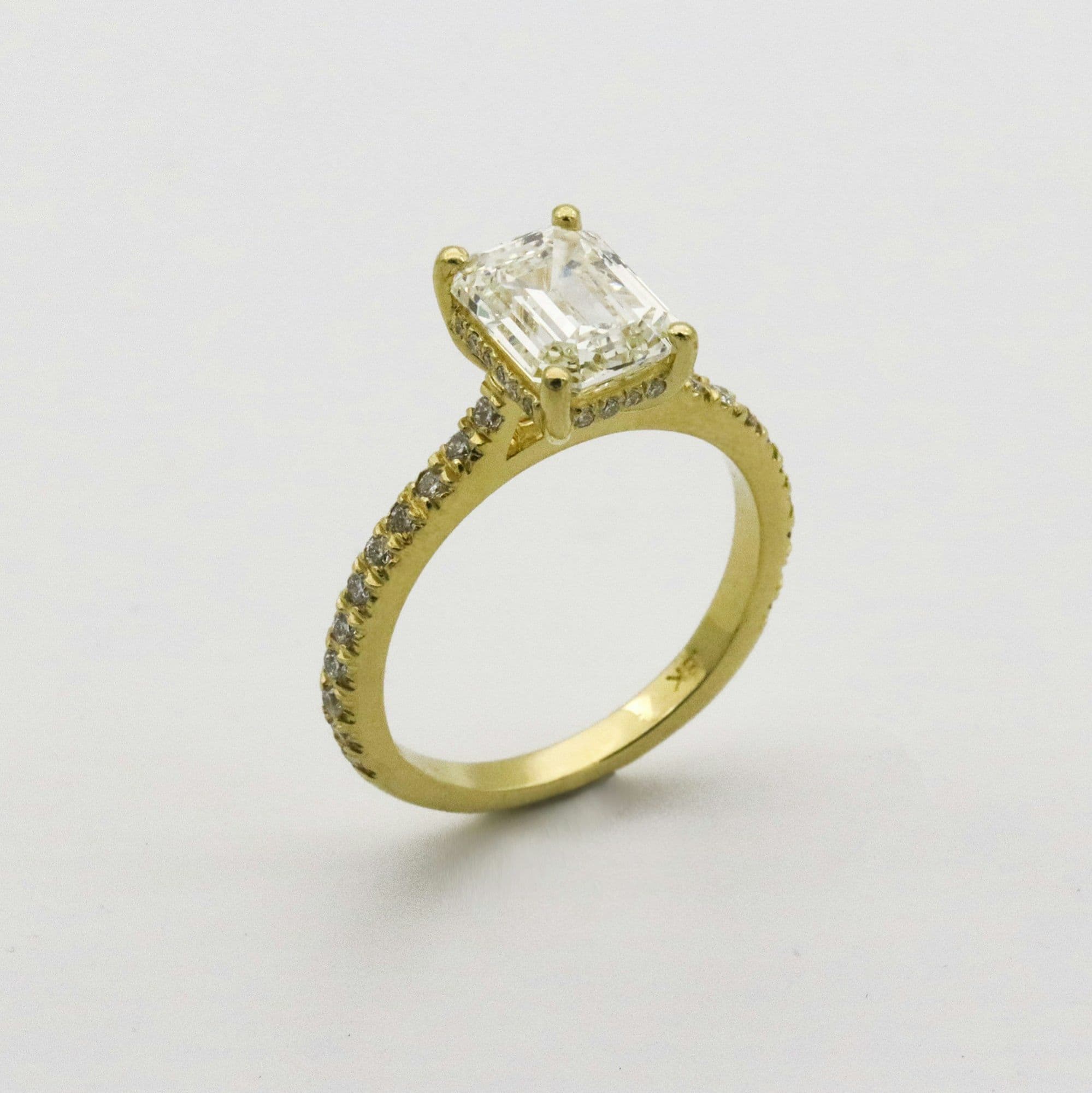 Emerald-cut ring on a yellow-gold pavé band