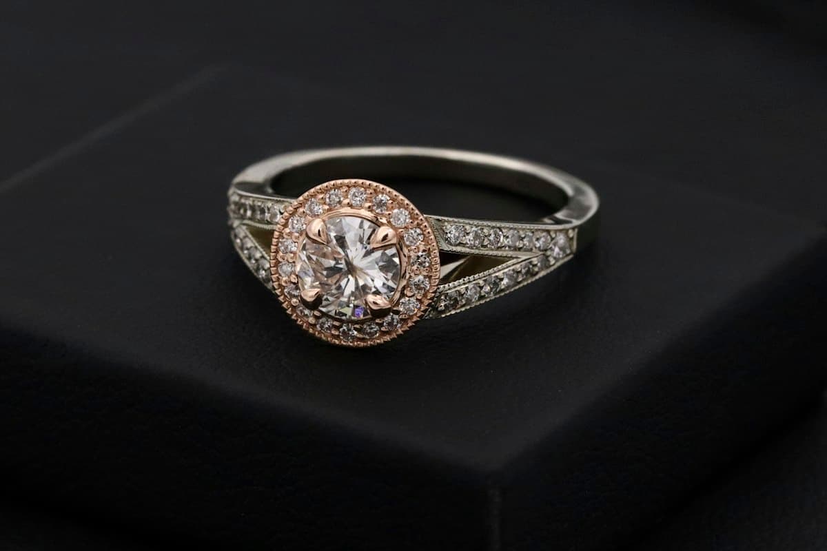 Laboratory-grown diamond halo engagement ring on a dark surface