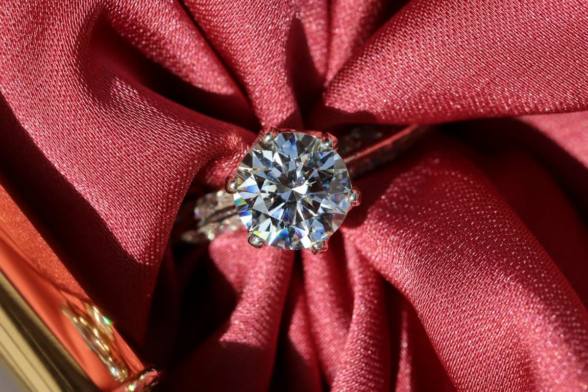 Round brilliant engagement ring on satin