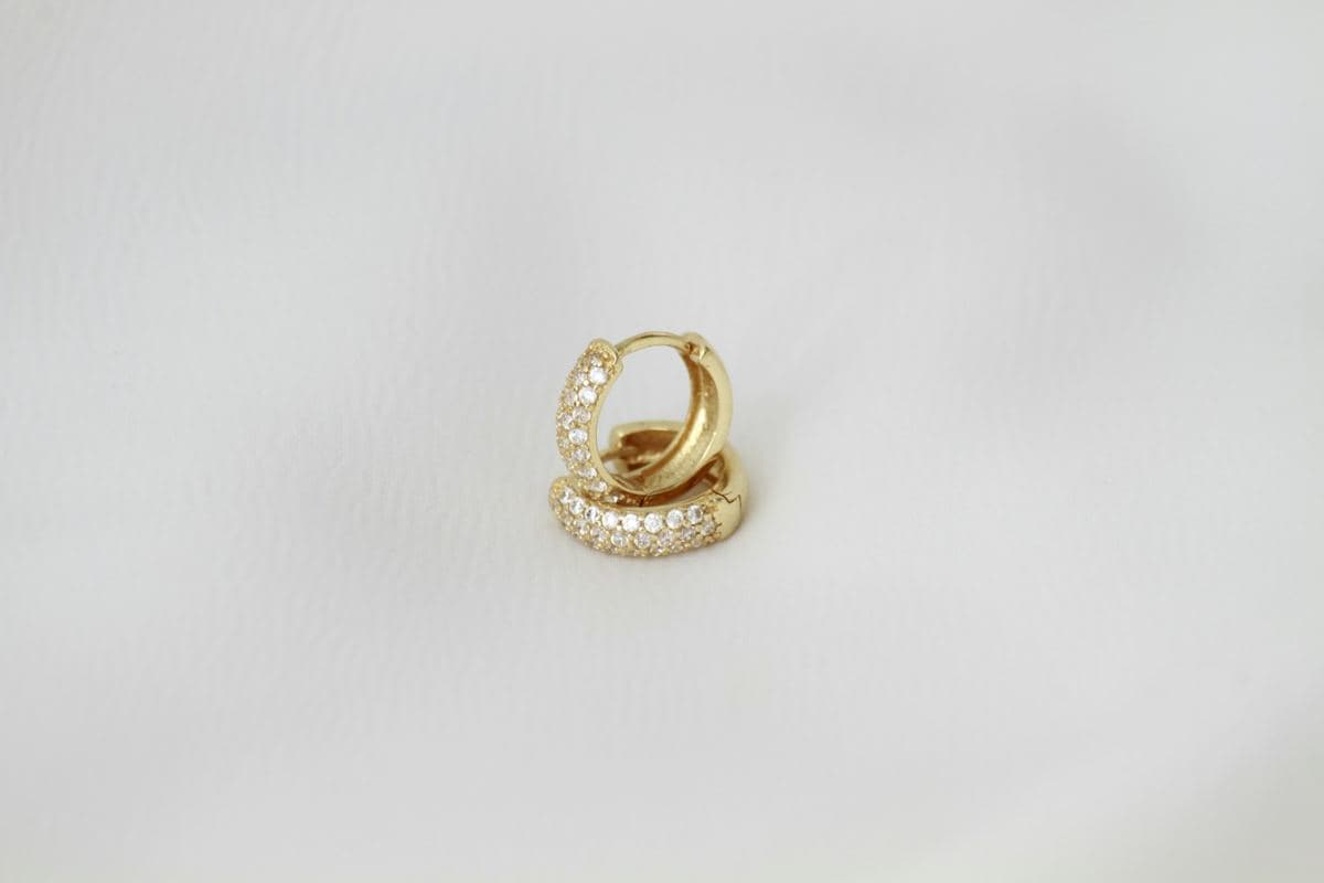 Pair of rounded huggies with pave round stones across the front, yellow gold, stacked