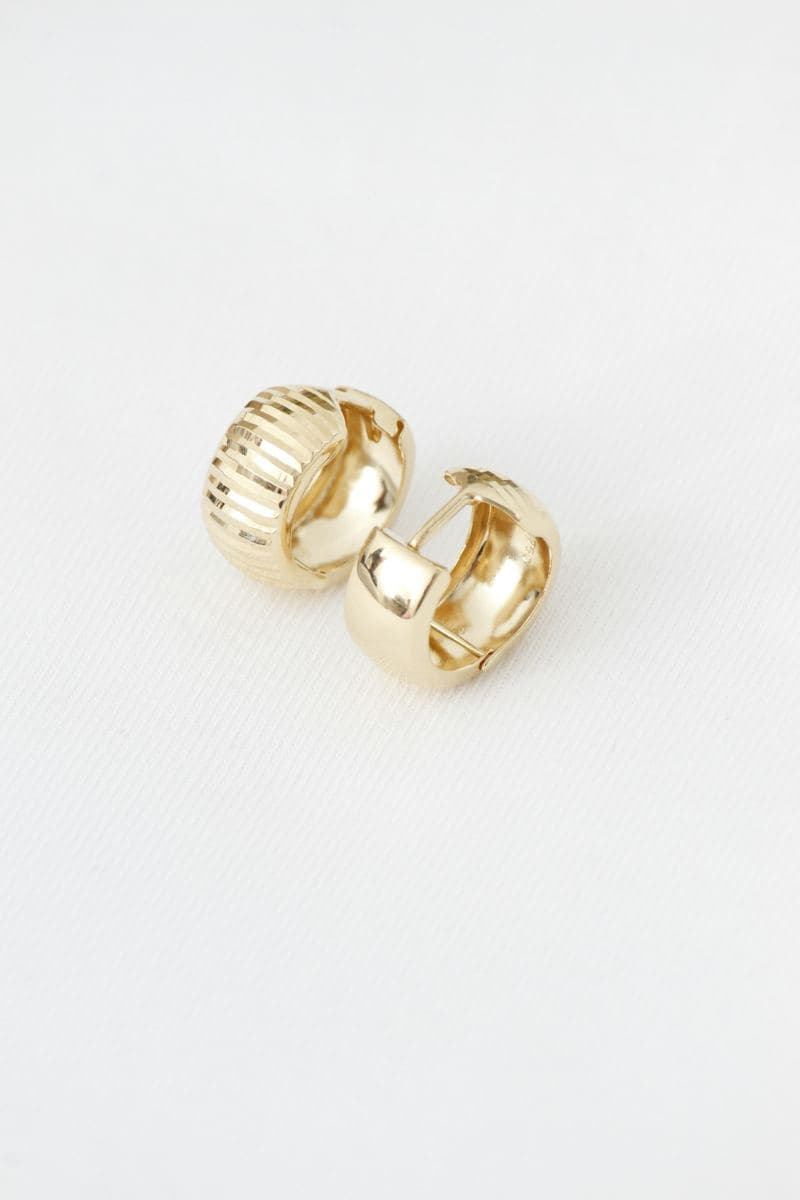 Pair of wide yellow-gold huggies with stone-cut ridged texture and polished inner surfaces stamped 750
