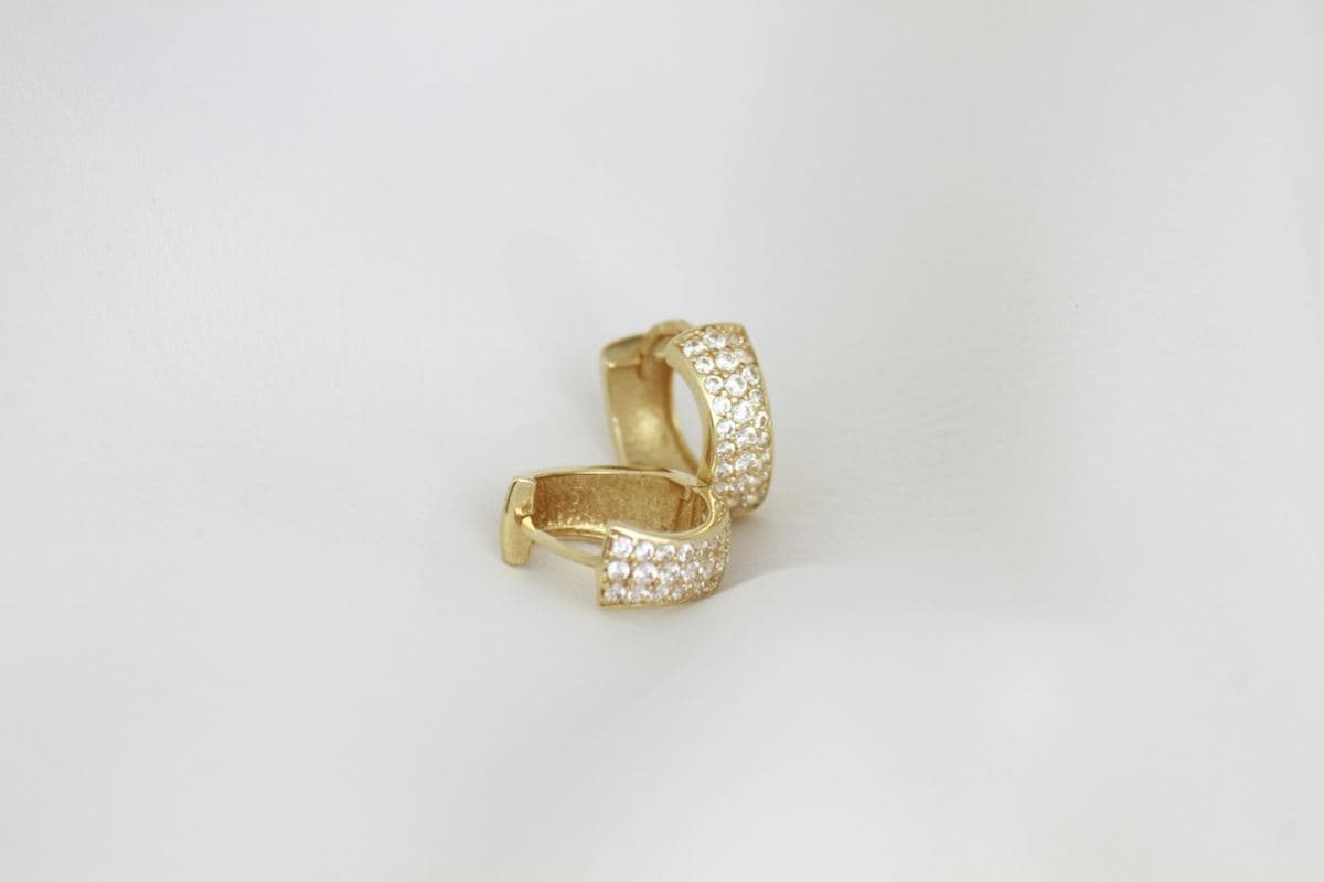 Pair of wide huggies with three rows of pave round stones on the front, yellow gold