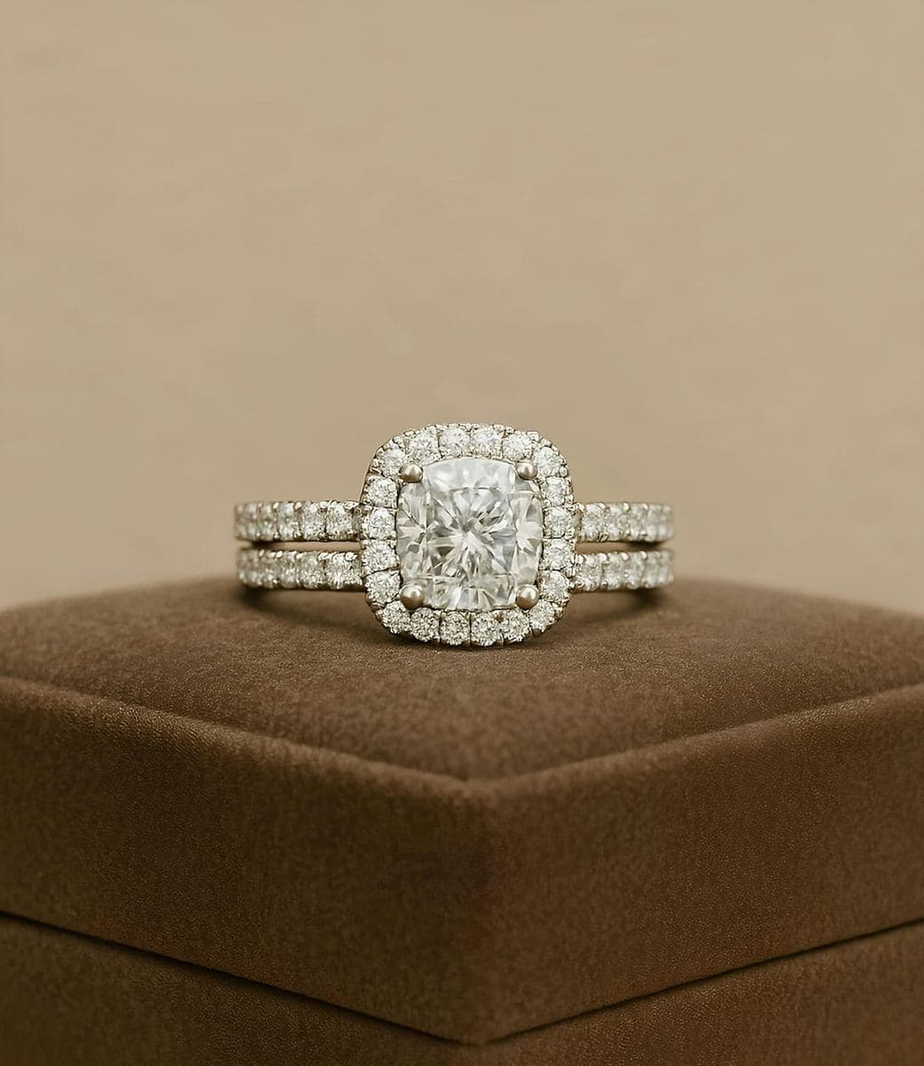 Cushion-cut center in a stone halo on a pavé band, stacked with a matching pavé wedding band