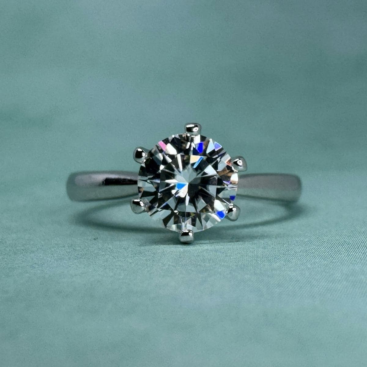 Large round brilliant in a six-prong head on a plain tapered white-metal band, shot head-on