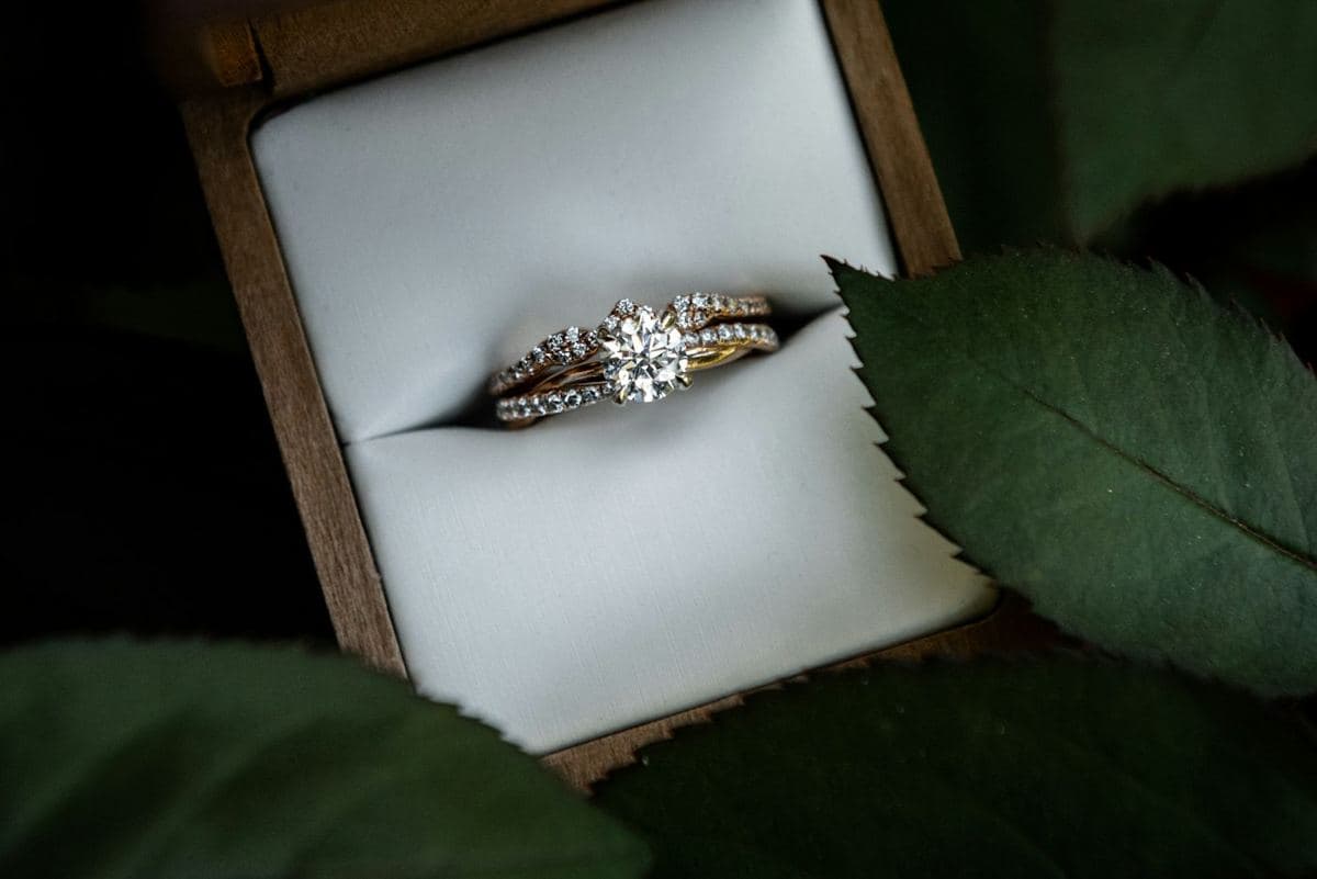 Round center in prongs on a pavé yellow-gold band, nested with a matching curved pavé band in a box