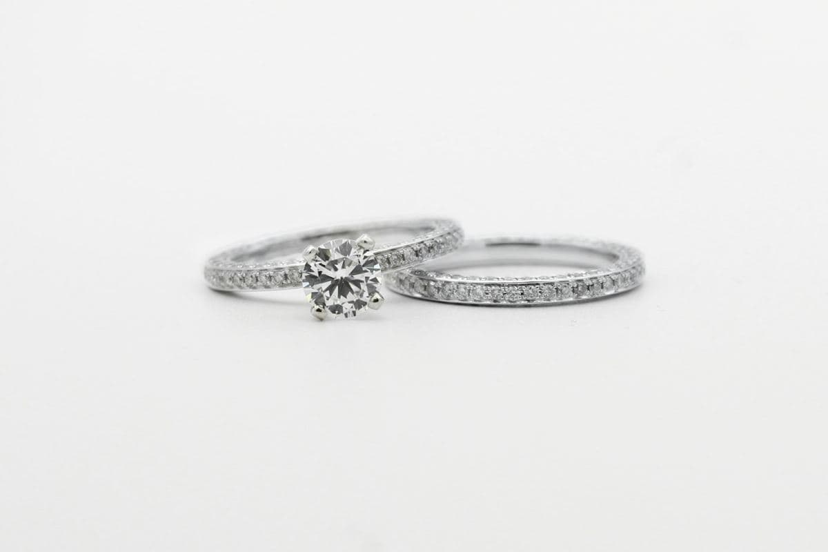 Round center in four prongs on a pavé band beside a matching pavé eternity-style band