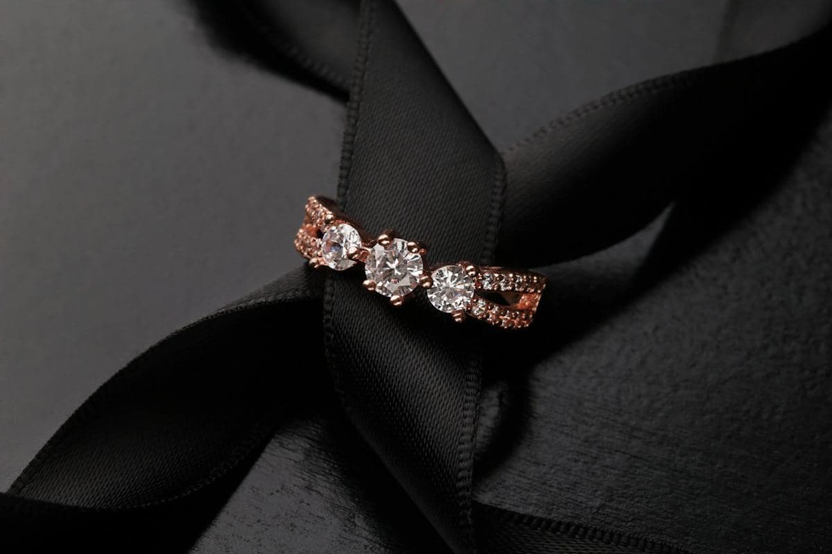 Three round stones in rose-gold prongs on a split pavé rose-gold shank