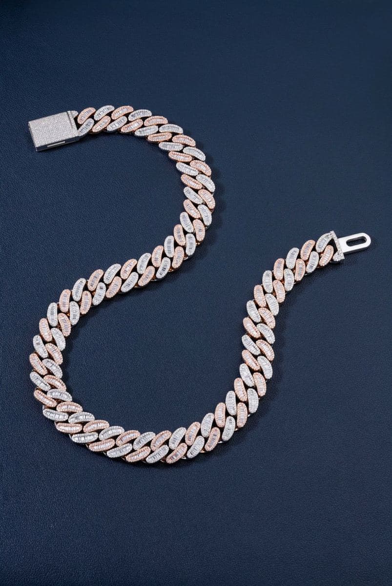 Flat-lay S-curve of a cuban link chain with alternating rose-gold and white-gold links, each set with baguettes bordered by small round stones, white pavé box clasp