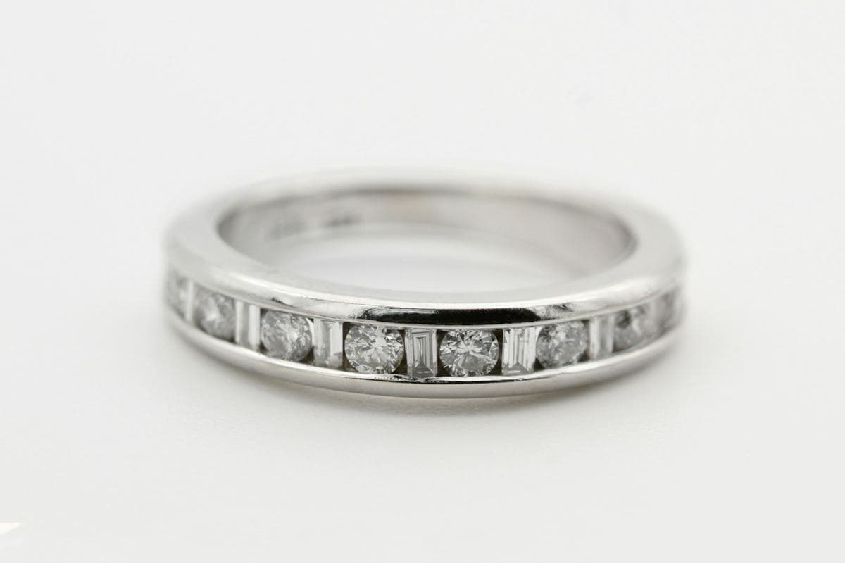 A white gold channel-set band alternating round brilliant stones and baguettes