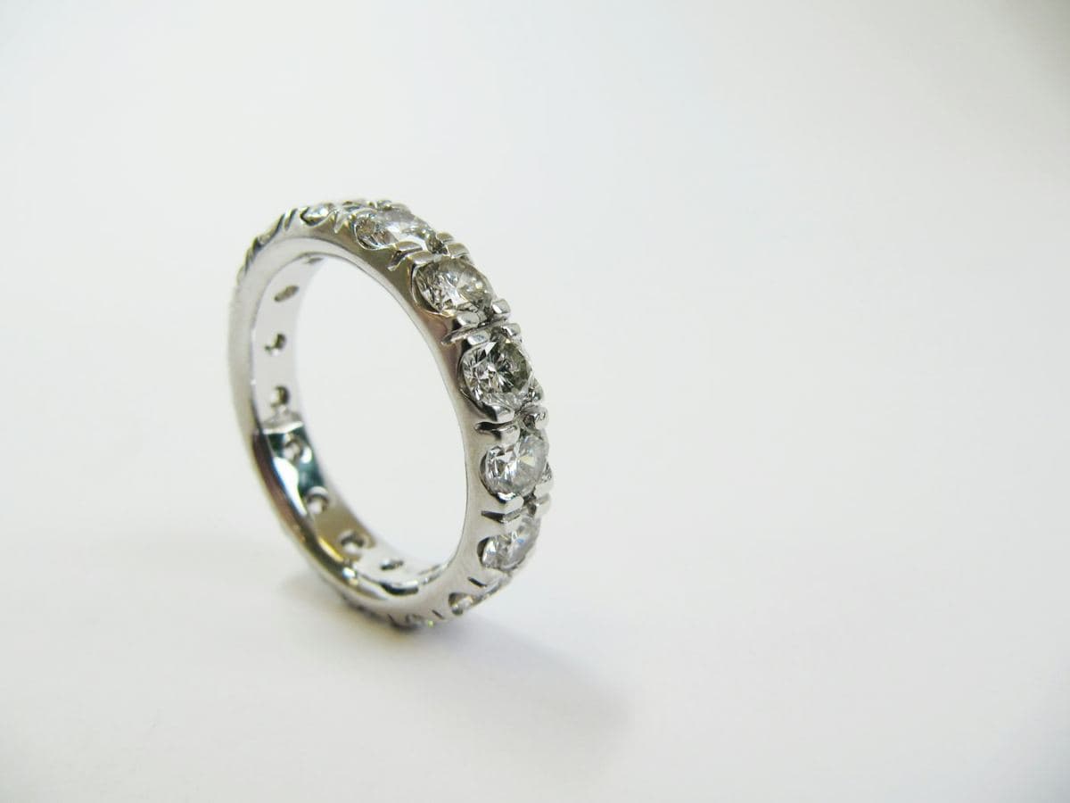 A white gold full eternity band of prong-set round stones continuing all the way around