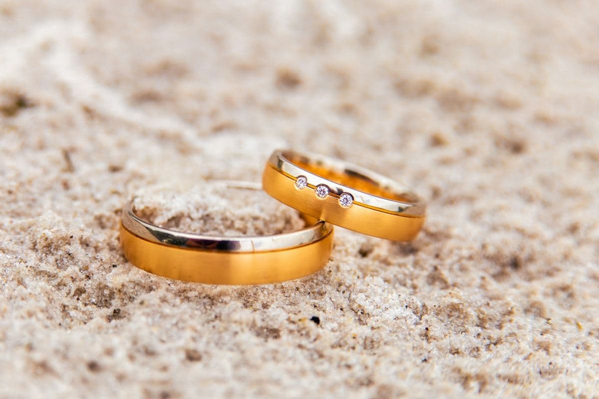 Two satin yellow gold bands with a polished white gold edge, the narrower one set with three small round stones
