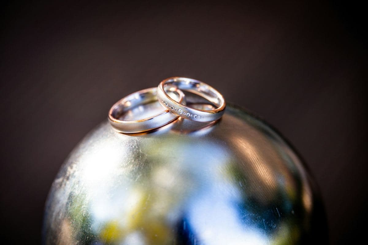 Two satin white gold bands with rose gold edges, one with a row of small flush-set stones