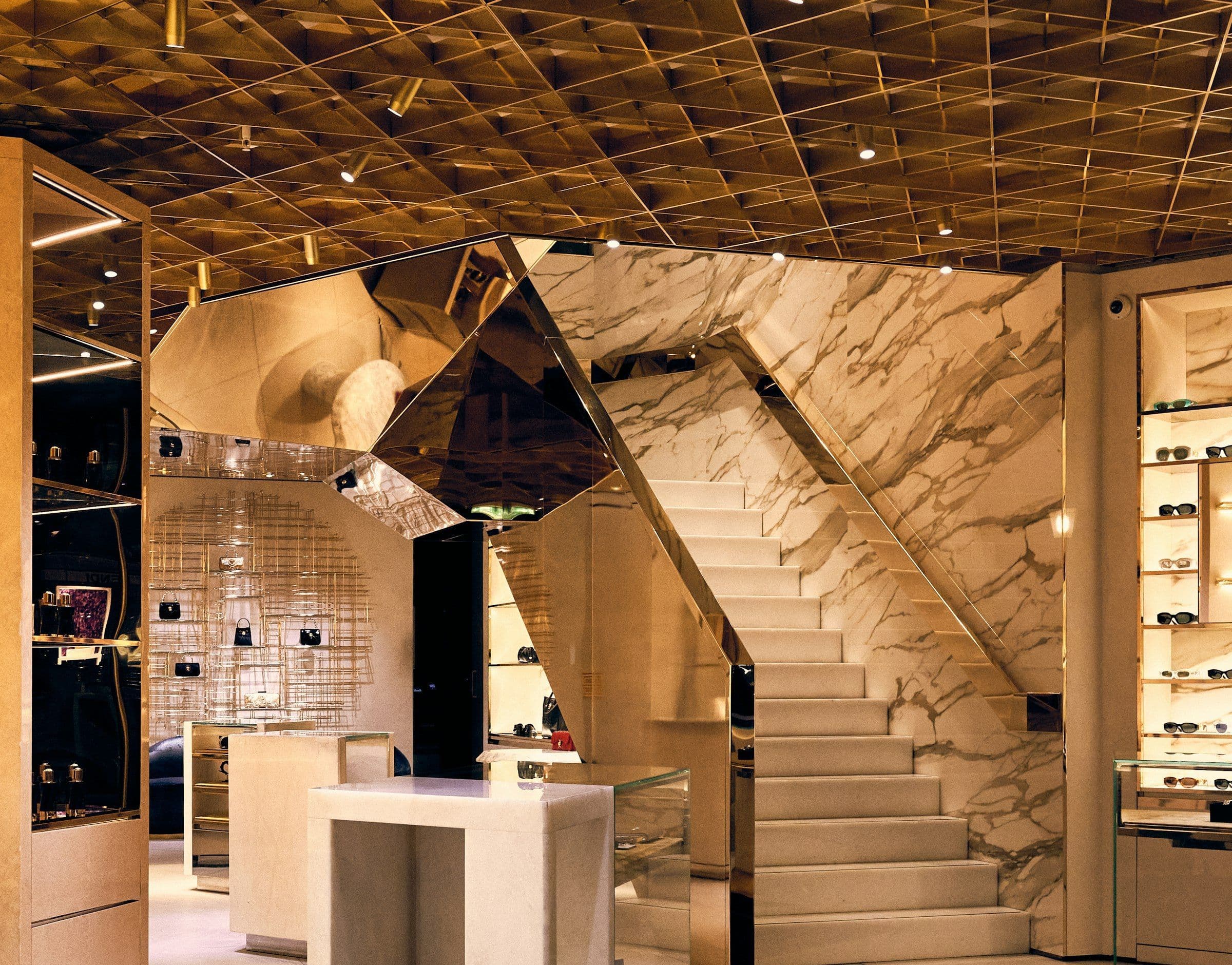 A white-and-gold jewelry showroom with a marble staircase